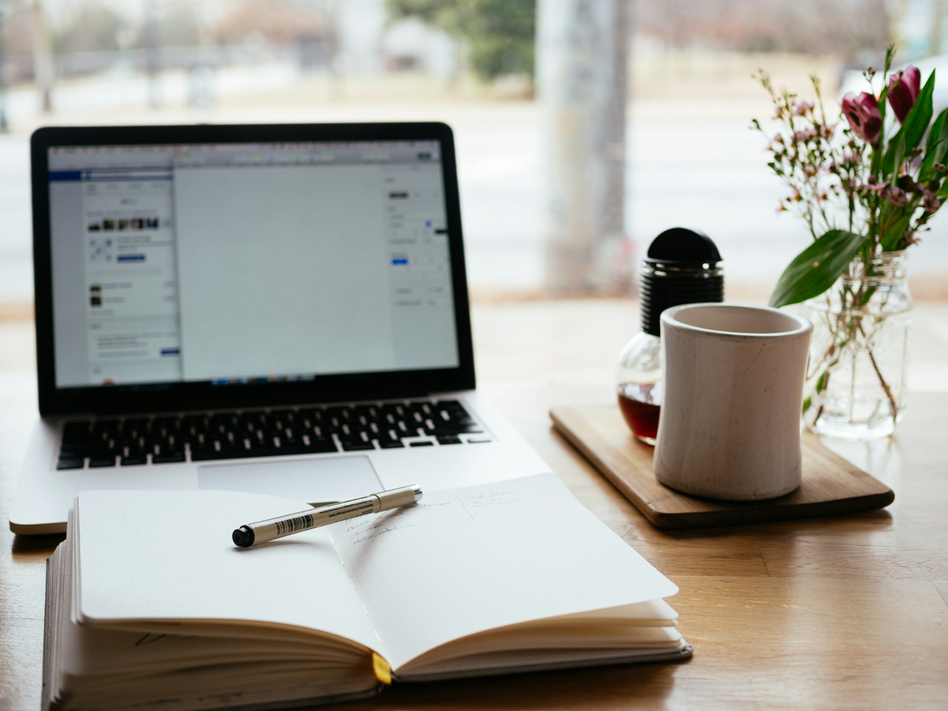 A notebook and pen in front of a laptop